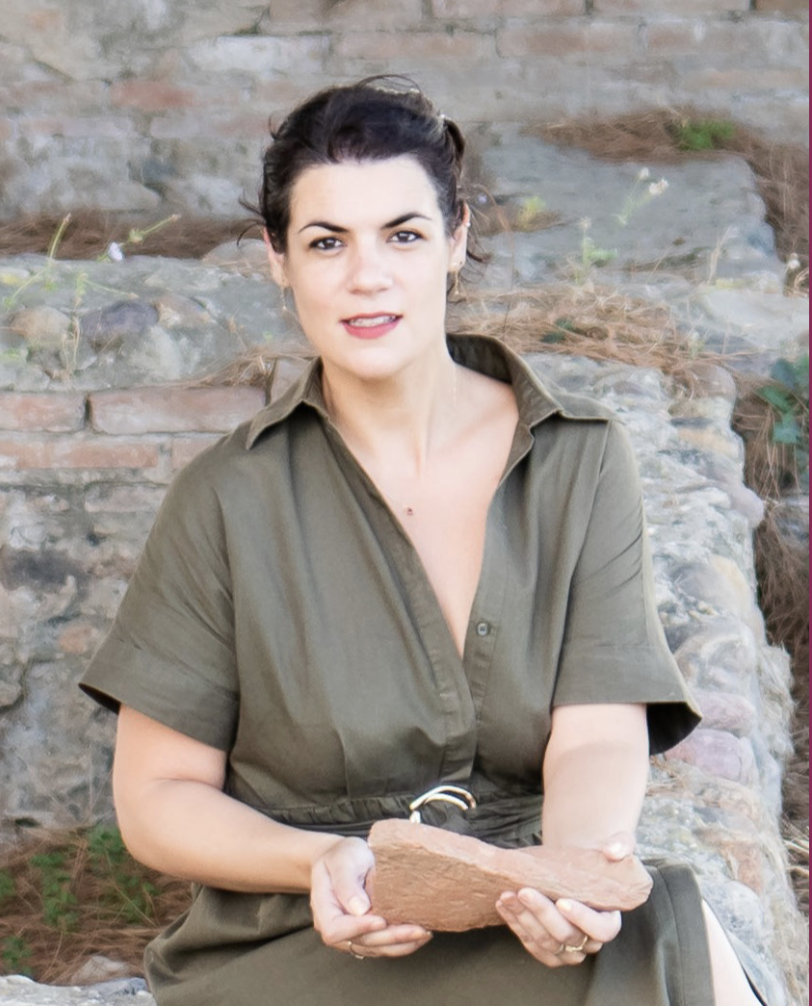 headshot of dr. celia orsini, holding a rock